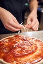 Close up man adding ingredients on dough