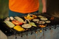 A close up shot of a man putting all kinds of different veggies on an outside grill and they get all steamy and cooked Royalty Free Stock Photo