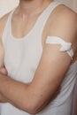 Close up shot of a man`s body: shoulder and arm with a bandage after rabies vaccination