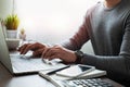 Close-up shot of man`s hand with watch on his wrist. using keyboard of laptop computer on office desk. Royalty Free Stock Photo