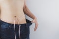 Close up shot of man with slim body measuring his waistline and torso. Healthy nutrition, diet and weight losing concept Royalty Free Stock Photo