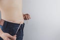 Close up shot of man with slim body measuring his waistline and torso. Healthy nutrition, diet and weight losing concept Royalty Free Stock Photo