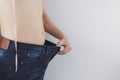 Close up shot of man with slim body measuring his waistline and torso. Healthy nutrition, diet and weight losing concept Royalty Free Stock Photo