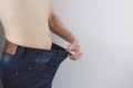 Close up shot of man with slim body showing his diet results. Healthy nutrition, diet and weight losing concept Royalty Free Stock Photo