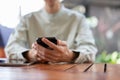 A close-up shot of a man using his smartphone at a table in a cafe Royalty Free Stock Photo