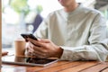 A close-up shot of a man using his smartphone at a table in a cafe Royalty Free Stock Photo