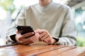 A close-up shot of a man using his smartphone at a table in a cafe Royalty Free Stock Photo