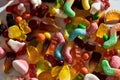 Close up shot of many tasty colorful gummies made from fruit juice, gelatin and sugar on white background