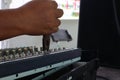 Close-up shot of a mechanic holding pliers to repair an audio mixer