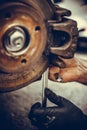 Mechanic working at a car worn and rusty brake disk and caliper Royalty Free Stock Photo