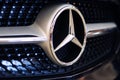 Close-up shot of the Mercedes-Benz logo on car grill
