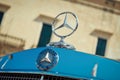 Close-up shot of Mercedes Benz logo hood ornament on the bonnet of a car