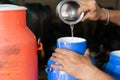 Close up shot, milk dairy farmer mixing water into milk container at farmhouse - conept of Milk Adulteration, and Royalty Free Stock Photo