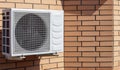 Close-up shot of a modern climate control unit against the background of a brick wall of the facade of a house outside. Air Royalty Free Stock Photo