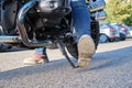 Close-up shot of motorcyclist positioning the kickstand