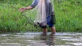A close-up shot of a net with a fisherman walking down a river to catch fish, Thai equipment Royalty Free Stock Photo
