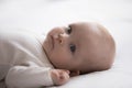 Close up shot newborn baby in bodysuit lying on bed Royalty Free Stock Photo