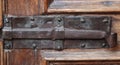 Close-up shot of an old antique metallic latch and deadbolt lock of a wooden door Royalty Free Stock Photo