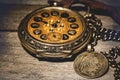 Close-up shot of an old antique vintage round mechanical pocket watch with a compass on a table Royalty Free Stock Photo