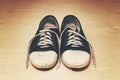 Old dirty shabby sneakers over light wooden background Royalty Free Stock Photo