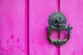 Close-up shot of an old door knocker on a pink wooden door Royalty Free Stock Photo