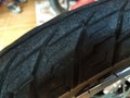 Close up shot of old motorcycle tire that has no sign of rubber tile