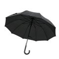 A close-up shot of an open black umbrella with raindrops on its surface isolated on a white background, generated by ai isolated Royalty Free Stock Photo
