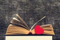 Close-up shot of open old book with red heart by side Royalty Free Stock Photo