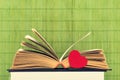 Close-up shot of open old book with red heart by side Royalty Free Stock Photo