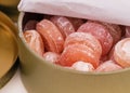 A closeup shot of an open tin box full of fruit drop candies
