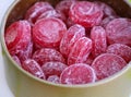 Close-up shot of an open tin box full of sour cherry drop candies