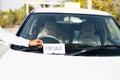 Close up shot of owner placing car for sale sign board in front of car - concept of business loss, personal probleams