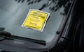 A close up shot of a parking ticket that was issued for illegally parking on a street in London