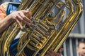 A close-up shot of a part of a tuba with a person in the background. Royalty Free Stock Photo