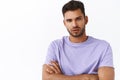 Close-up shot passionate serious-looking macho man with bristle, wear purple t-shirt, squinting gazing camera, cross