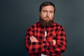 Close-up shot passionate serious-looking macho man with bristle, wear red checkered shirt, squinting gazing camera, cross arms