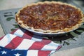 Close up shot of a pecan pie cooling. American classic homemade pecan pie. Amish pies. Napkin a flag of USA. Royalty Free Stock Photo