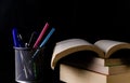 Close up shot of a pen stand with stationary items in it and pile of books with one opened -Higher Study concept Royalty Free Stock Photo