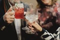 Close up shot of people tapping their glasses of drinks to cheers Royalty Free Stock Photo