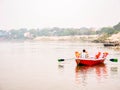 Close up shot of person boating in lake with defocused village over the background