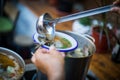 Person serving a portion of fish soup