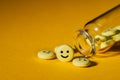 close-up shot of pills with smiley faces and glass bottle Royalty Free Stock Photo