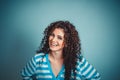 Close up shot portrait of stylish young woman smiling against blue background wall Royalty Free Stock Photo