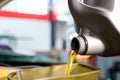 Close-up shot of pouring oil into the engine compartment Auto mechanic in car repair shop is pouring golden yellow engine oil in Royalty Free Stock Photo