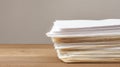 Stack of papers on wooden surface with neutral background Royalty Free Stock Photo