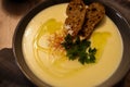 Close up shot of a pumpkin cream soup in a black plate with fried bread and parsley on top Royalty Free Stock Photo