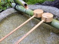 Close up shot of purification fountain with bamboo and wooden scoop Royalty Free Stock Photo
