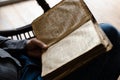 Close up shot of reading lines from the Bible. Man hands holding a big heavy book. Male studying christianity rules and Royalty Free Stock Photo