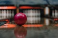 close-up shot of red bowling ball lying on alley under warm light Royalty Free Stock Photo