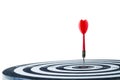 Close up shot red dart arrow on center of dartboard Isolated on